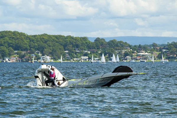 Um marinheiro júnior a subir de volta a bordo de um barco à vela . — Fotografia de Stock