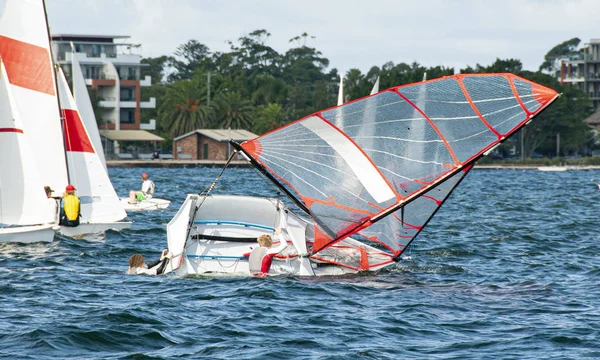 Niños subiendo de nuevo en un velero volcado con en un inlan — Foto de Stock