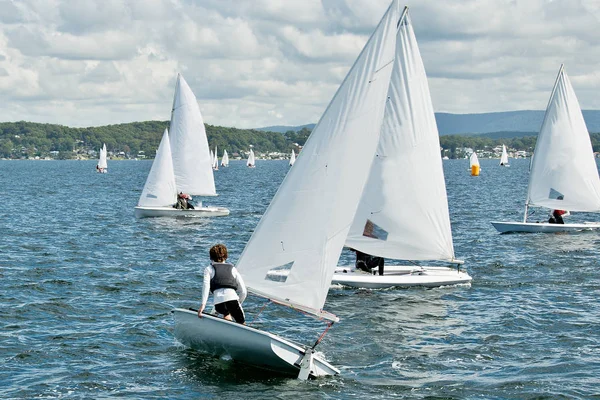 Child sailor on watch in close school children sailboat racing o — Stock Photo, Image