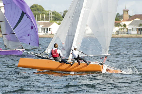 Children Sailing a catamaran sailboat at speed with one hull air — Stock Photo, Image