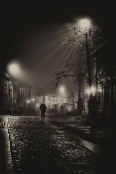 On the way home - single man on the Baklandet foggy streets, night walk in Trondheim\'s old town.