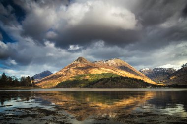 Glencoe Pap dağ İskoçya Highlands yansımaları. Sonbahar renkleri ve ağır bulut dağ yukarıda. Scotland, İngiltere.