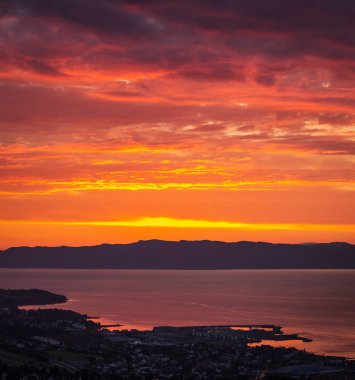 Günbatımı gökyüzü ve uzak şehir Ranheim Norveç'te. Uzak deniz manzaralı. Güzel gökyüzü ve bulutlar renkleri.