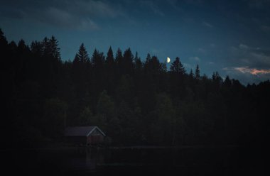 Trondheim, Norveç Jonsvatnet shore gölün saat akşam. Ormanın içinde moon.