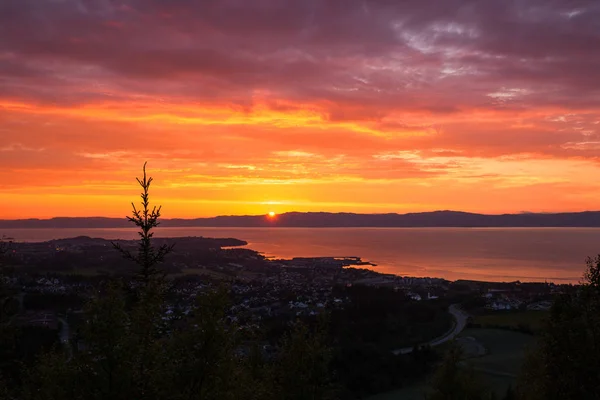 Sunset sky and distant city Ranheim in Norway. Distant sea view. Beautiful sky and clouds colours.