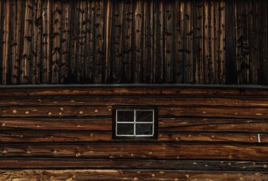 Ahşap mimari pencere nedeni. Eski ahşap ev. Karanlık eski plakalar. Duvar yüzeyi.