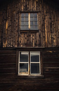 Ahşap mimari pencere nedeni. Eski ahşap ev. Karanlık eski plakalar. Duvar yüzeyi.