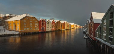 Eski ahşap binalar, dergiler, Nidelva Nehri, kış döneminde Trondheim, Norveç kıyıları tarafından.