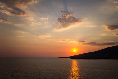 Saranda Arnavutluk. Yaz günbatımı şehir binaları yukarıda. Güzel bir akşam gökyüzü. sakin Adriyatik Denizi.