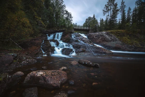 Evening mood in boreal forests of Norway. Waterfalls on river Homla. Long exposure shot. Natural light and colours.