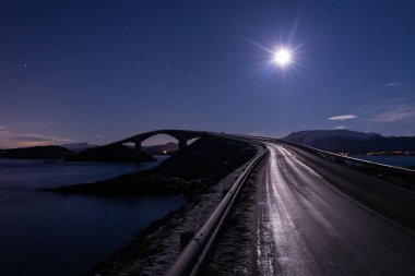 Gece ay ve Norveç'te Atlantic Ocean Road (Atlanterhavsveien) görünümü ile. Kış manzara ve renkler. Storseisundbrua köprüde görüntülemek.