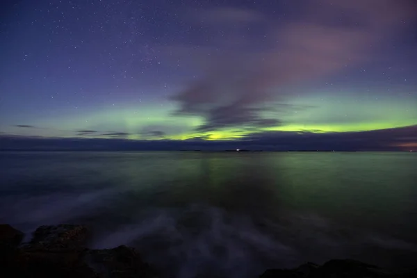 North lights Aurora Borealis seen from Atlantic Ocean Road - Atlanterhavsveien in winter night. Norwegian wintertime. Nice starry sky and green lights.