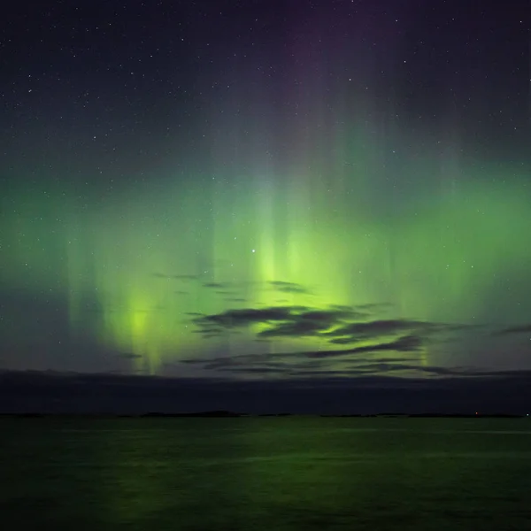 North lights Aurora Borealis seen from Atlantic Ocean Road - Atlanterhavsveien in winter night. Norwegian wintertime. Nice starry sky and green lights.