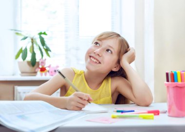 Ödev yapan genç bir kız. Masasında oturuyor. Evde rüya gören bir çocuğun duygusal portresi.