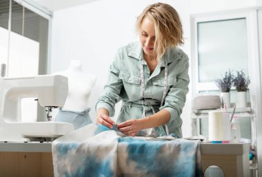 Terzinin bir düzeni var. Terzi atölyesindeki kumaşlı dikiş makinesi..