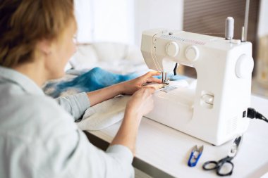 Terzi atölyesindeki kumaşlı dikiş makinesi. Dikiş işlemi. Küçük bir iş konsepti olarak hobi dikiş dikmek