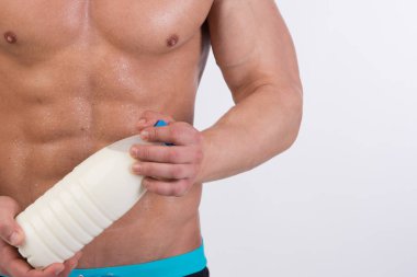 Spor ve diyet. Kas vücut ile çekici bir adam. Atletik adam ve şişe süt. Sağlıklı beslenme