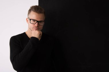 Genç yakışıklı adam dinleniyor. Akıllı, kas ve seksi. Kontrast arka plan