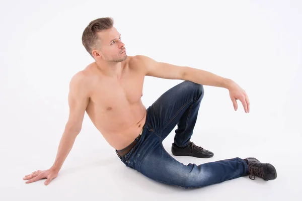若いハンサムな男は休んでいます 上半身裸の男は 床に座っています 筋肉でセクシーです 灰色の背景 — ストック写真