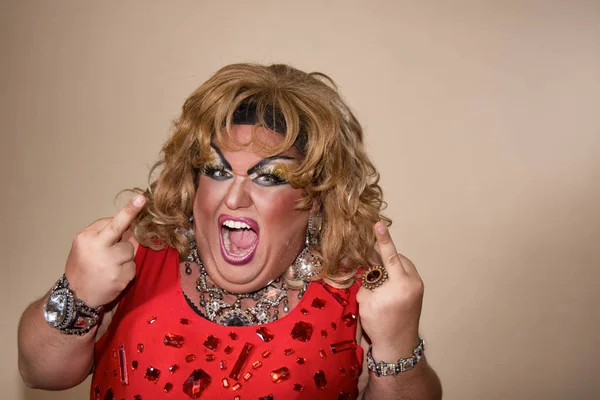 Funny travesty actor. Drag queen in red. Feelings and emotions. Fat man and make-up