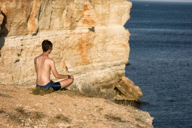 Genç bir adam denizde dinleniyor. Sakin ol.