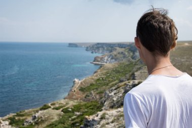 Genç bir adam denizde dinleniyor.