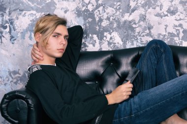 Kanepede oturan bir tablet ile bir öğrenci.