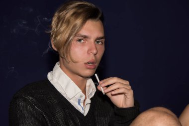 Kötü alışkanlıkları. Çekici adam sigara içiyor.