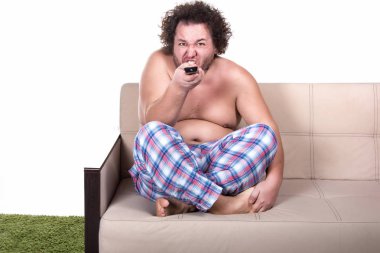 Komik şişman adam evde televizyon izliyor..