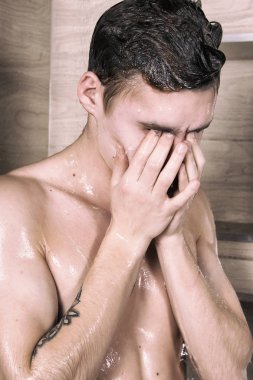 Duştaki genç seksi adam.