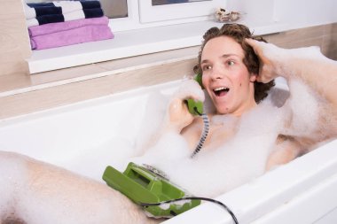 Banyoda telefonu olan komik bir genç adam..