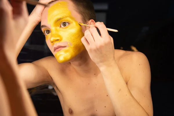 Make up. Attractive guy is painting.