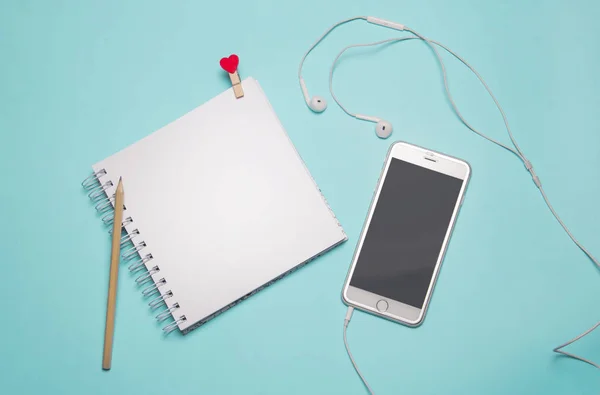 Een laptop en een smartphone met koptelefoon — Stockfoto