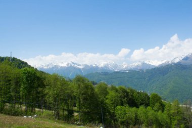 Güzel dağ manzarası ve yaz güneşli çayırlar. Güzel mavi bulutlu gökyüzü. Yeşil dağlar ve tepeler