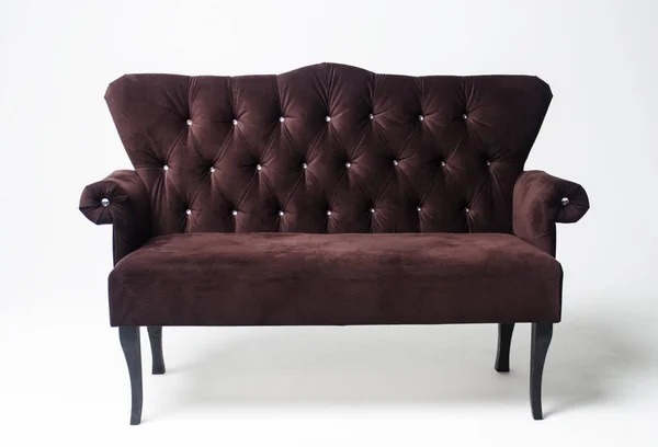 Velvet classic sofa on a light background. Brown sofa with wooden legs