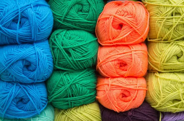 Fils multicolores. Le fil est beige, brun, gris et blanc. Aiguilles à tricoter, ciseaux, café, tricot, tricot . — Photo