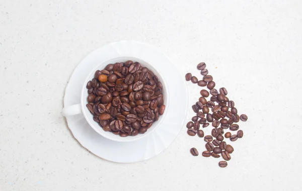 Zubereitung von Kaffee. Kaffeebohnen in einer weißen Tasse. — Stockfoto