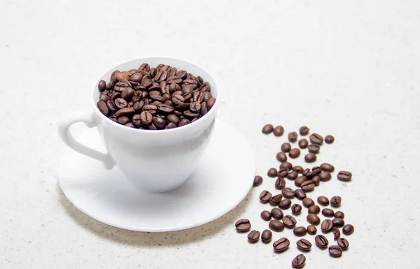 Zubereitung von Kaffee. Kaffeebohnen in einer weißen Tasse. — Stockfoto