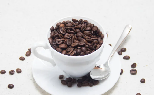 Kaffeebohnen in einer weißen Tasse. Zubereitung von Kaffee. — Stockfoto