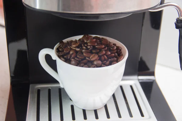 Kaffeebohnen in einer weißen Tasse. Zubereitung von Kaffee. — Stockfoto