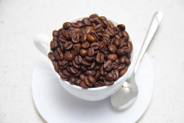 Kaffeebohnen in einer weißen Tasse. Zubereitung von Kaffee. — Stockfoto