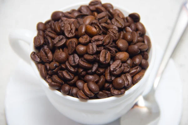 Kaffeebohnen in einer weißen Tasse. Zubereitung von Kaffee. Nahaufnahme — Stockfoto