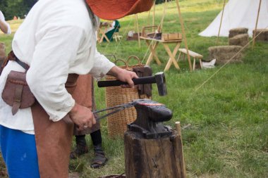 Blacksmithing. Çekiç ve örs. Demirci demir ilerler. Ortaçağ yeniden inşası