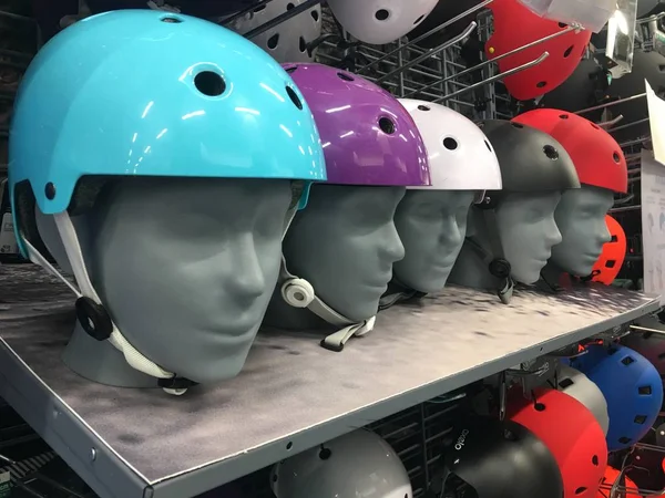 선반에 오토바이 다채로운 헬멧 가게. 상점에서 여러 가지 색상의 보호 자전거 헬멧. 헬멧을 쓰고 있는 마네킹 — 스톡 사진