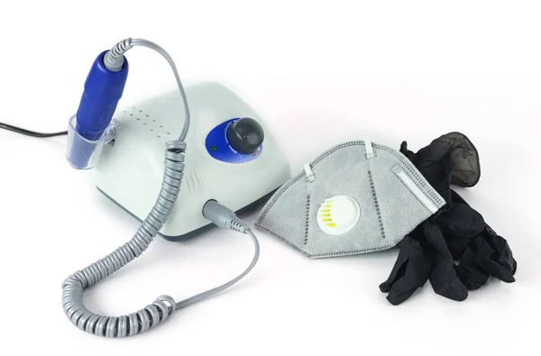 Utensili e attrezzature per manicure. Una maschera medica e guanti di gomma si trovano accanto alla macchina manicure . — Foto Stock