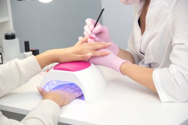 Tırnaklarına oje süren kadının yakın çekimi.