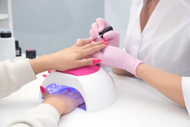 Tırnaklarına oje süren kadının yakın çekimi.