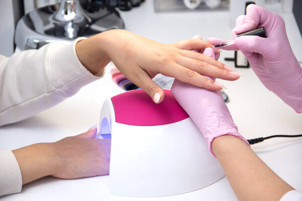Woman doing a manicure and applying nail polish