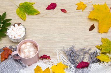 Kakao ve marşmelov. Sonbahar konsepti üst görünüm. Sıcak kakao ya da eski ahşap tahtaların üzerinde lokum olan sıcak çikolata. Kahve, kakao, sıcak çikolata, sonbahar yaprağı, rahat battaniye.