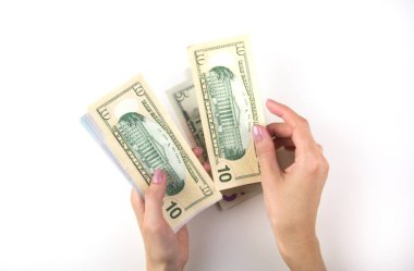 Kadın eli para sayar. Kadınlar bir tomar doları elle sayar.